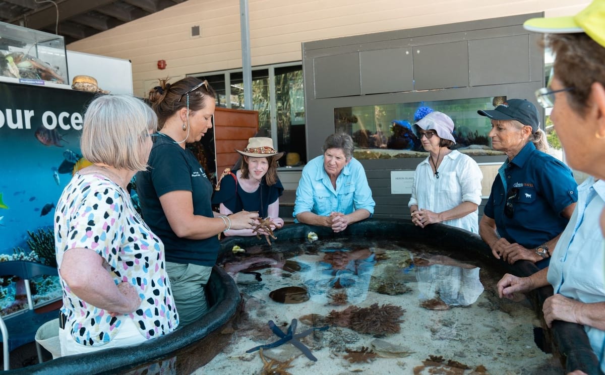 Visitors interacting with marine biologists at an educational touch tank tank